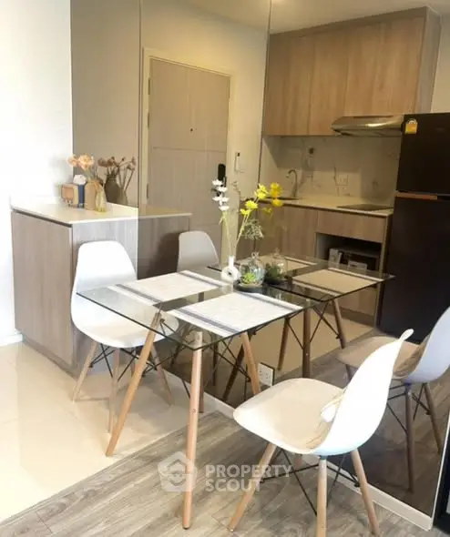 Modern kitchen with dining area featuring glass table and stylish chairs