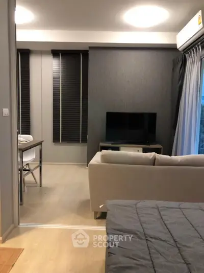 Modern living room with sleek design and cozy ambiance, featuring a comfortable sofa and flat-screen TV.