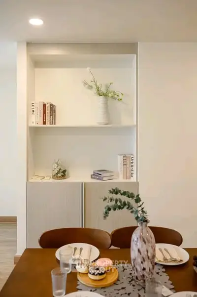 Stylish dining area with elegant table setting and modern built-in shelving, perfect for contemporary living.