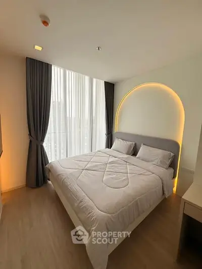 Modern bedroom with stylish lighting and large window in a contemporary apartment.