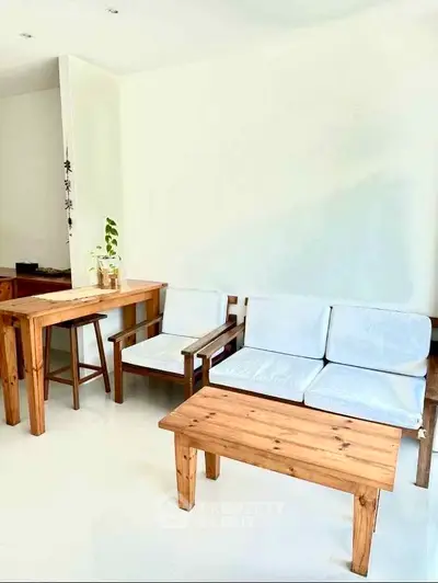 Bright and airy living room with minimalist wooden furniture and white walls.