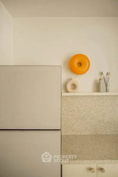Modern kitchen with sleek design and terrazzo countertop, featuring minimalist decor and neutral tones.