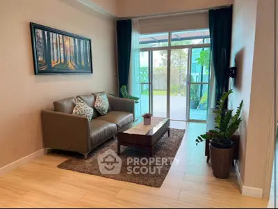 Charming living room with cozy sofa and garden view, perfect for relaxation.