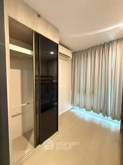Spacious bedroom with modern closet and large window for natural light