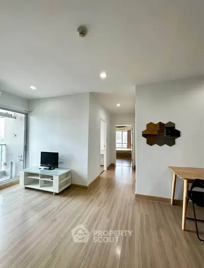 Spacious modern living room with wooden flooring and natural light