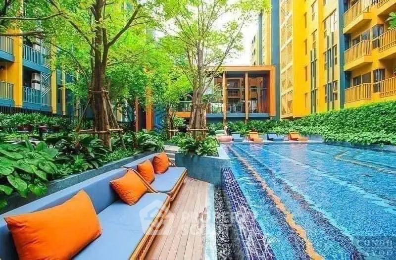 Luxurious apartment complex with vibrant pool and lush greenery