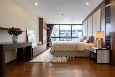 Luxurious bedroom with modern decor and large window offering city view