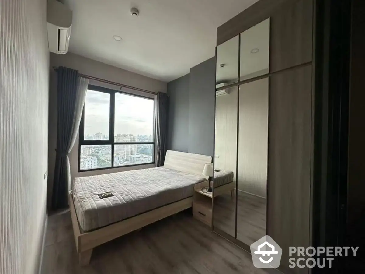 Modern bedroom with city view, featuring sleek design and ample natural light.