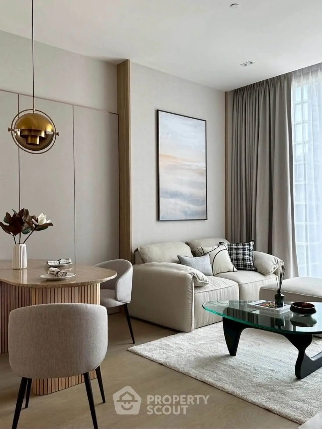 Modern living room with stylish decor, featuring a cozy sofa, elegant dining area, and large window with natural light.