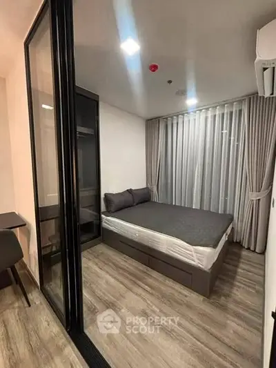 Modern bedroom with glass partition and stylish decor in a contemporary apartment.