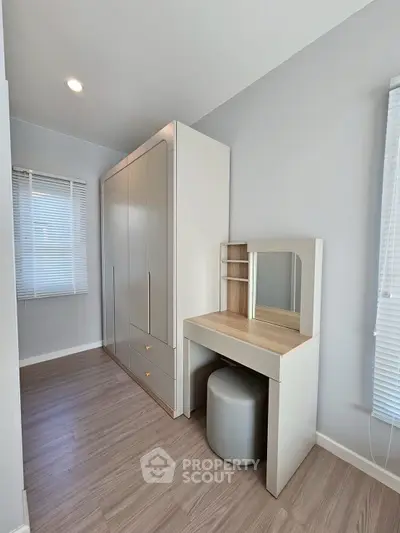 Modern bedroom with sleek wardrobe and stylish vanity in bright natural light.