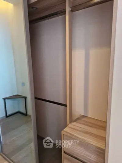Spacious walk-in closet with modern wooden finish and ample storage space.