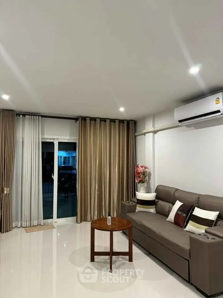 Modern living room with sleek sofa, elegant curtains, and air conditioning in a stylish apartment.