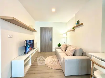 Modern living room with cozy sofa, TV, and stylish decor in a bright apartment.