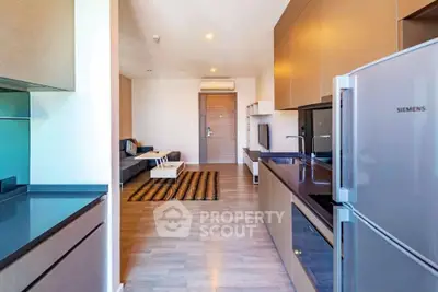 Modern open-layout kitchen and living room with sleek appliances and stylish decor
