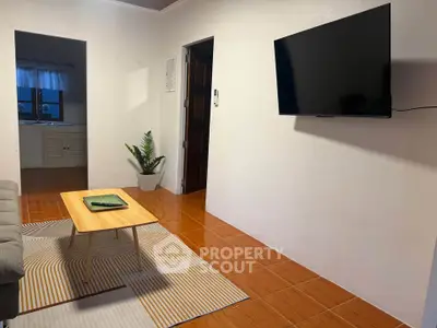 Cozy living room with modern TV and stylish coffee table, perfect for relaxation.