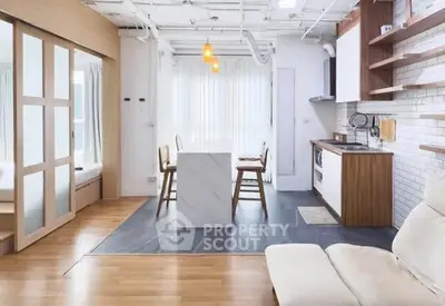 Modern open-layout kitchen and living area with sleek design and natural light.