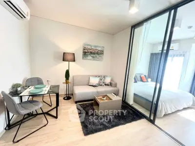 Modern studio apartment with seamless living and sleeping areas, featuring sleek furniture, a plush rug, and ample natural light.
