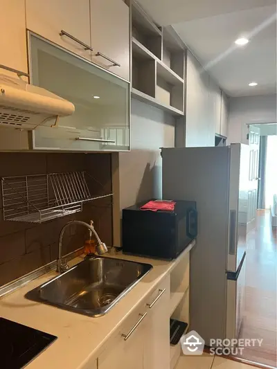 Modern kitchen with sleek cabinetry and stainless steel appliances in a stylish apartment.