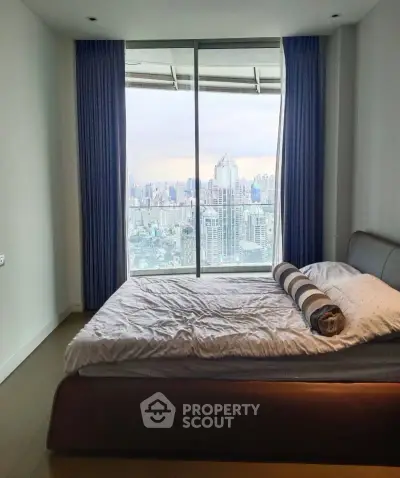 Luxurious bedroom with stunning city view from large window, featuring elegant bed and modern decor.