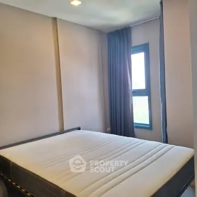 Spacious bedroom with large window and modern design in prime real estate location.