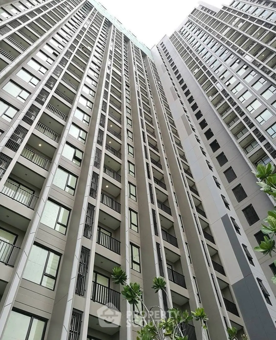 Stunning high-rise building exterior with modern architectural design and lush greenery.
