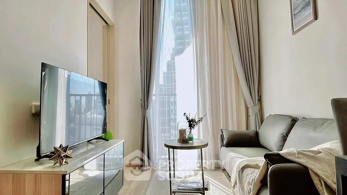 Modern living room with large window, sleek furniture, and natural light in urban apartment.