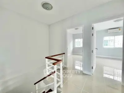 Bright and spacious interior with glossy tiled floors and modern staircase in a contemporary home