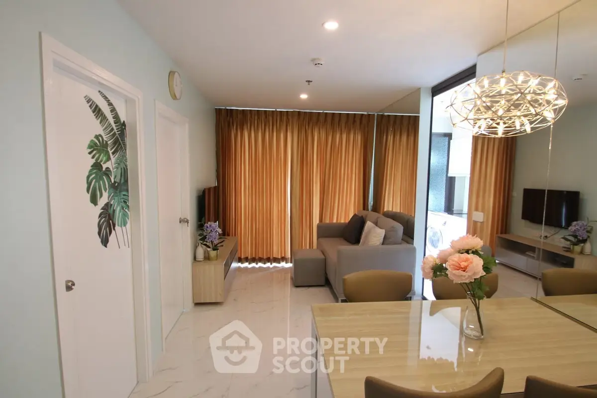 Modern living room with elegant decor and natural light, featuring a cozy sofa and stylish dining area.