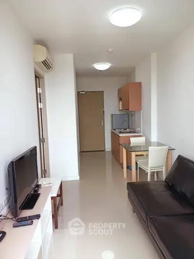 Modern apartment interior with sleek furniture and compact kitchen area.