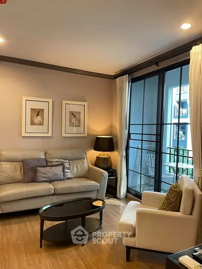 Elegant living room with cozy seating and balcony view, perfect for relaxation and entertaining.