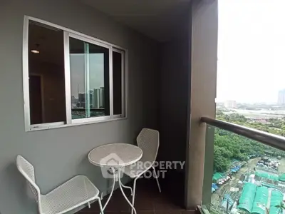 Charming balcony with city view and cozy seating area in modern apartment.