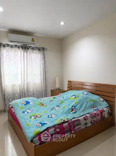 Cozy bedroom with modern wooden bed and bright natural light through curtains.