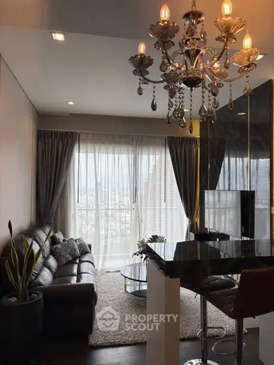 Luxurious living room with chandelier and city view, featuring elegant decor and modern furnishings.