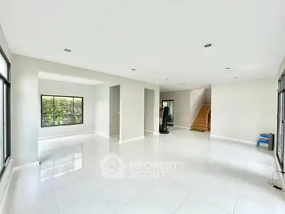 Spacious modern living room with large windows and sleek white flooring