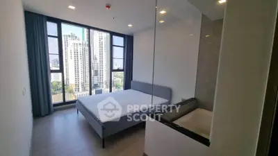 Modern bedroom with city view and glass partition, featuring sleek design and natural light.