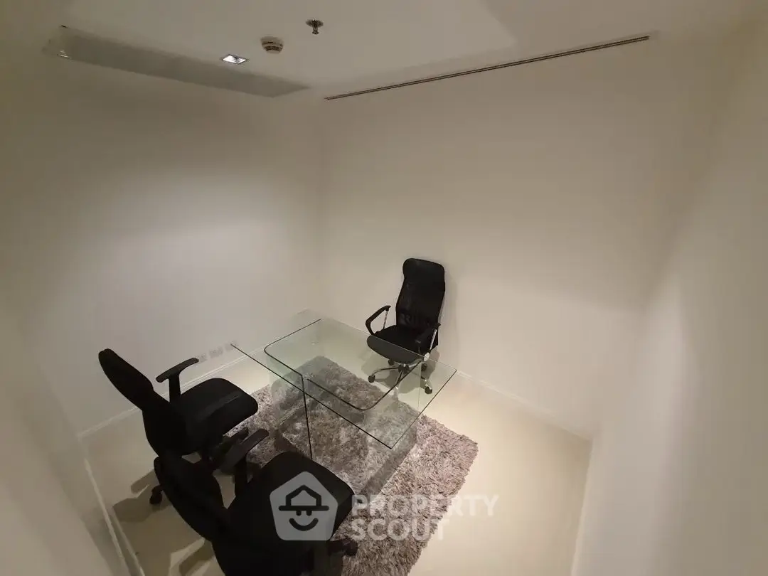 Modern minimalist office space with glass table and ergonomic chairs