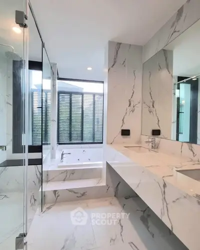 Luxurious marble bathroom with modern fixtures and large windows