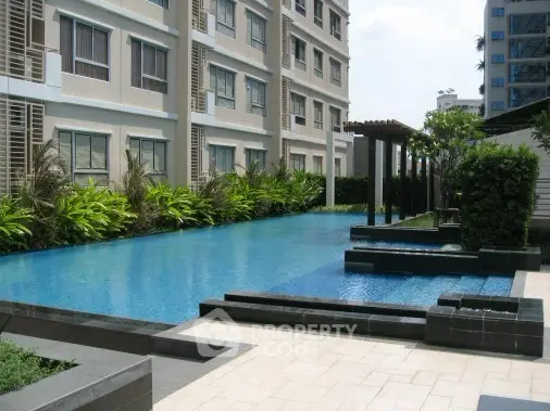 Luxurious apartment complex with stunning outdoor pool and lush greenery.