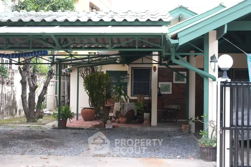 Charming house with covered patio and lush greenery in a serene neighborhood.