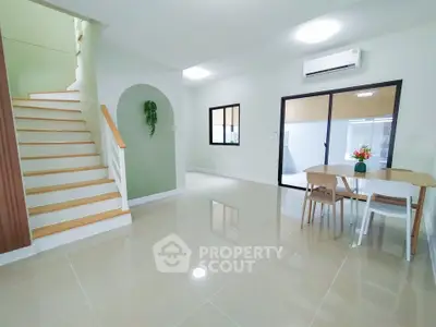 Spacious modern living area with sleek staircase and dining space, perfect for family gatherings.