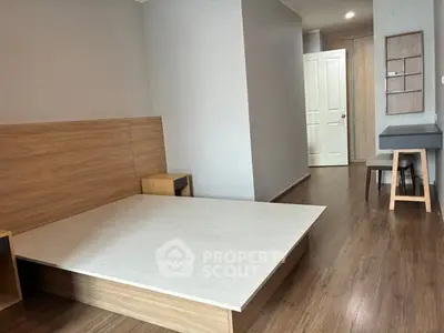 Modern minimalist bedroom with wooden flooring and sleek furniture design.