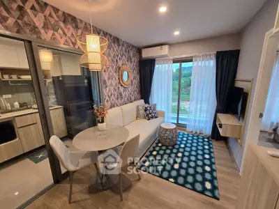 Modern living room with stylish decor and open kitchen layout, featuring a cozy seating area and large window view.