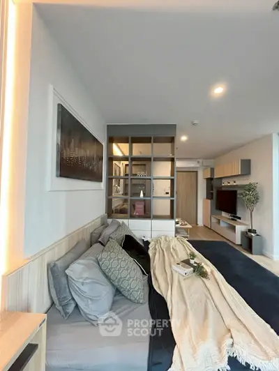 Modern living room with cozy bed and stylish decor in open layout apartment.