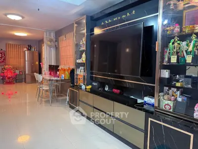 Spacious living room with modern entertainment center and dining area, perfect for family gatherings.