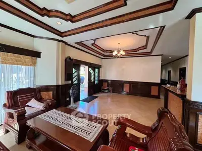 Spacious living room with elegant wooden furniture and intricate ceiling design