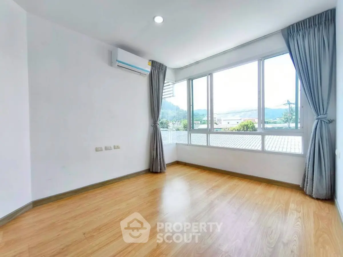 Bright empty room with large windows and scenic view, perfect for customization.