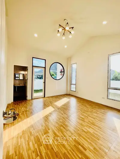 Spacious living room with wooden flooring and modern lighting in a bright home