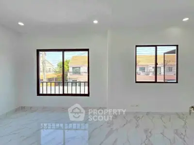 Bright and spacious room with large windows and marble flooring, perfect for modern living.