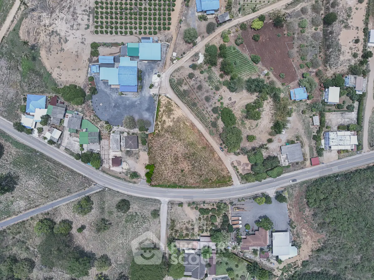 Aerial view of a rural area with scattered houses, roads, and agricultural fields.
